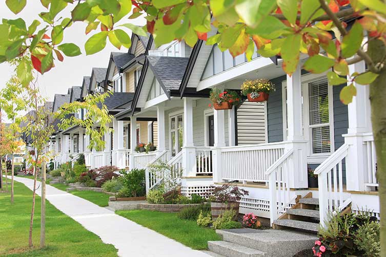 Houses in a row with sidewalk and trees